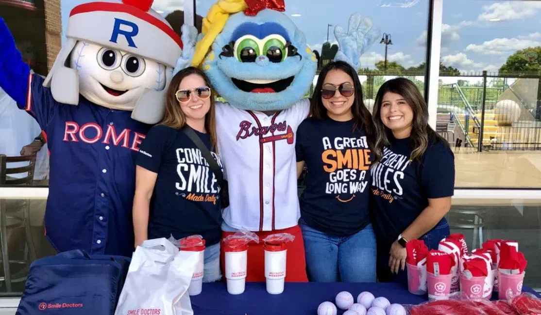 Soni and Snipes Orthodontics team at a local baseball event with mascots